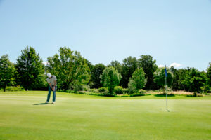 Man playing golf on golf course Man playing golf on golf course